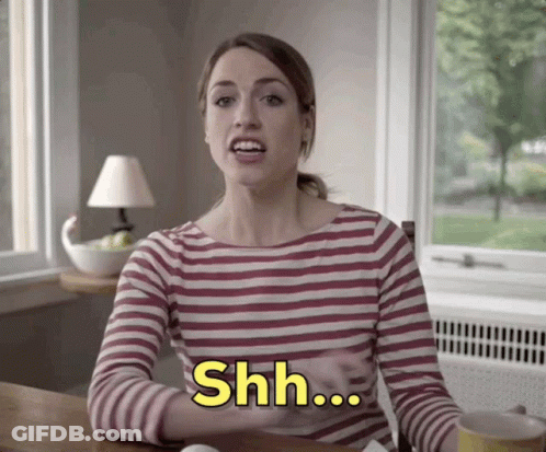 A Woman In A Striped Shirt Says " Shh " GIF