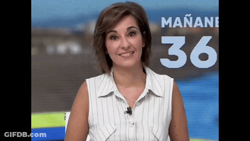 A Woman In A Striped Shirt Stands In Front Of A Sign That Says Mañana 36 GIF