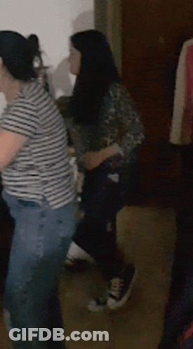 A Woman In A Striped Shirt Stands Next To Another Woman In Jeans GIF
