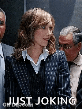 A Woman In A Striped Suit Is Standing In Front Of A Group Of People . GIF
