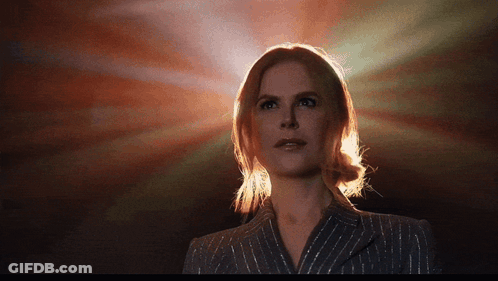 A Woman In A Striped Suit Is Standing In Front Of A Red Background GIF