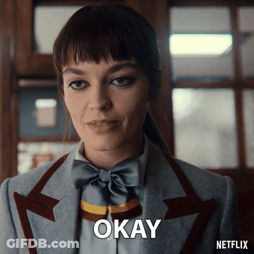 A Woman In A Suit And Bow Tie Says Okay On A Netflix Ad GIF
