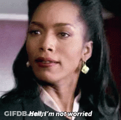 A Woman In A Suit And Earrings Is Talking About Not Being Worried . GIF