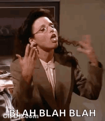 A Woman In A Suit And Glasses Is Making A Funny Face And Sticking Her Tongue Out . GIF
