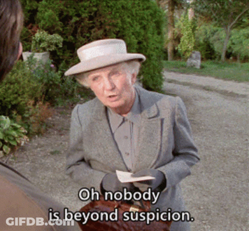 A Woman In A Suit And Hat Says Oh Nobody Is Beyond Suspicion While Holding A Briefcase GIF