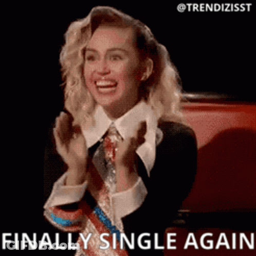 A Woman In A Suit And Tie Is Smiling And Clapping Her Hands . GIF