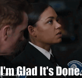 A Woman In A Suit And Tie Is Standing Next To A Man With The Words I 'M Glad It 'S Done Below Her GIF