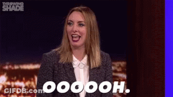 A Woman In A Suit And White Shirt Is Laughing And Saying Oooh . GIF