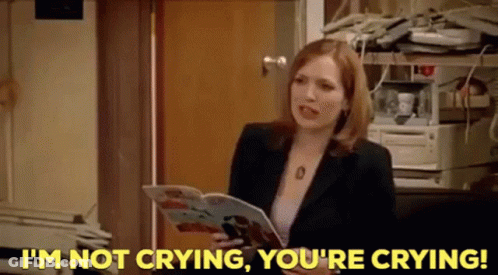 A Woman In A Suit Is Holding A Magazine And Saying I 'M Not Crying , You 'Re Crying . GIF