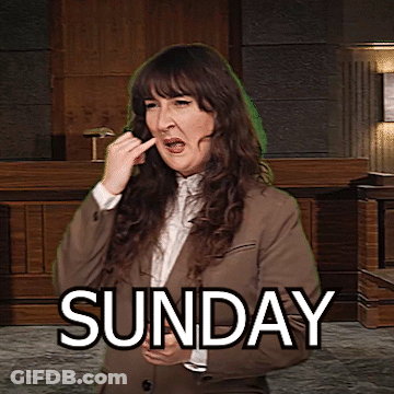 A Woman In A Suit Is Making A Funny Face In Front Of A Sign That Says " Sunday " GIF