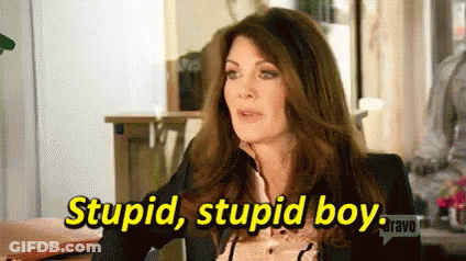 A Woman In A Suit Is Sitting At A Table And Says `` Stupid , Stupid Boy . '' GIF