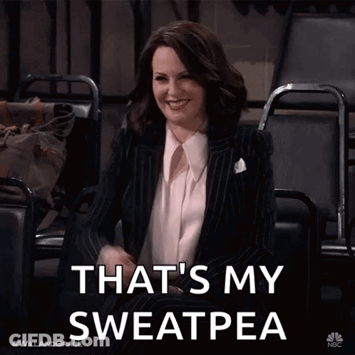 A Woman In A Suit Is Sitting In A Chair With The Words That 'S My Sweatpea GIF
