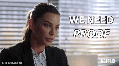 A Woman In A Suit Is Sitting In Front Of A Netflix Sign GIF