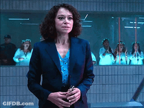Woman In Suit Standing In Front Of Women In White Dresses GIF