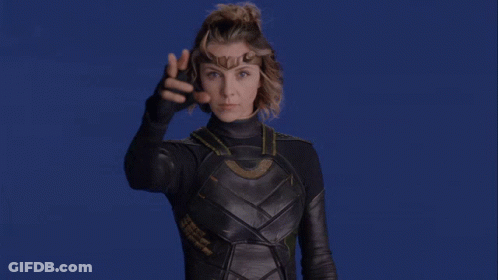 A Woman In A Superhero Costume Is Pointing At Something GIF