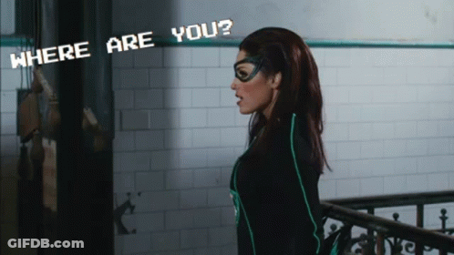 A Woman In A Superhero Costume Stands In Front Of A Sign That Says " Where Are You " GIF