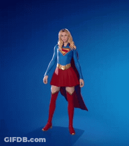 A Woman In A Superman Costume Is Dancing With Her Fist In The Air GIF