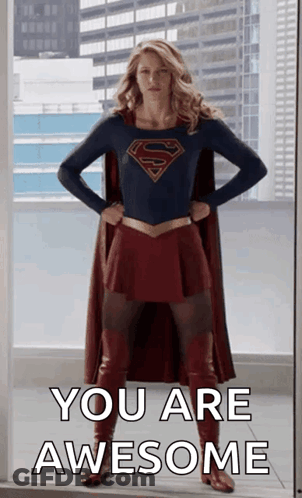 A Woman In A Superman Costume Is Standing In Front Of A Window With Her Hands On Her Hips And Says You Are Awesome . GIF