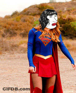 A Woman In A Superman Costume With A White Face On Her Face GIF