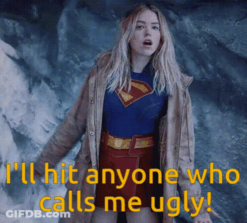 A Woman In A Superman Costume With The Words " I 'Ll Hit Anyone Who Calls Me Ugly " Below Her GIF