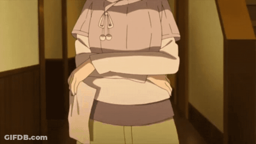 A Woman In A Sweater Is Standing In A Hallway GIF