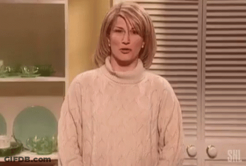Woman In Sweater Standing By Shelf Of Plates And Cups GIF