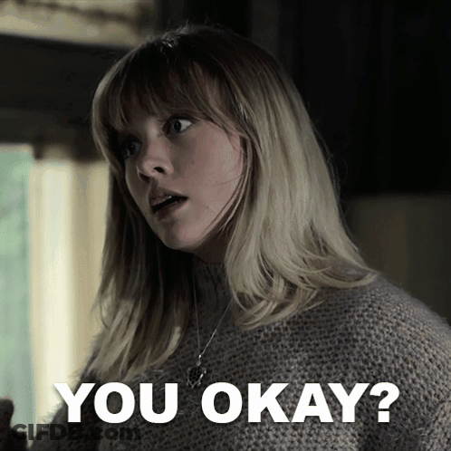 A Woman In A Sweater Says " You Okay " In Front Of Her GIF