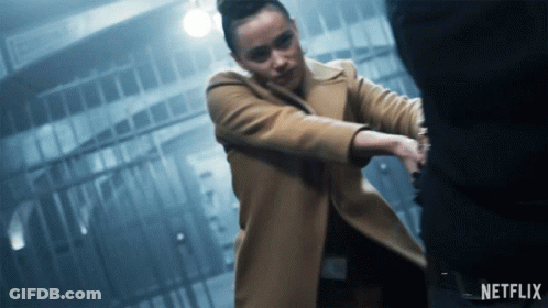 A Woman In A Tan Coat Is Holding A Man 'S Hand With A Netflix Logo In The Corner GIF