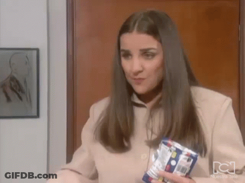 A Woman In A Tan Jacket Is Holding A Can Of Soda In Her Hand . GIF