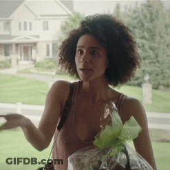 A Woman In A Tank Top Is Holding A Bag Of Grapes GIF