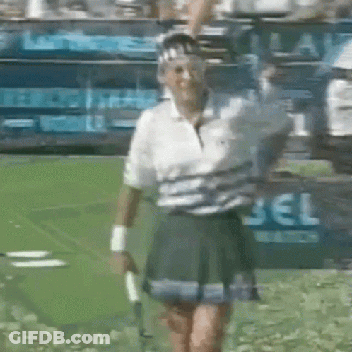 A Woman In A Tennis Skirt Is Holding A Tennis Racquet GIF
