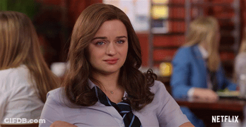 A Woman In A Tie Sits At A Table With Netflix Written On The Bottom GIF