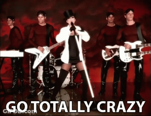 A Woman In A Top Hat Singing In Front Of A Band With The Words Go Totally Crazy Behind Her GIF