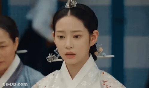 A Woman In A Traditional Korean Dress Is Standing In A Room . GIF