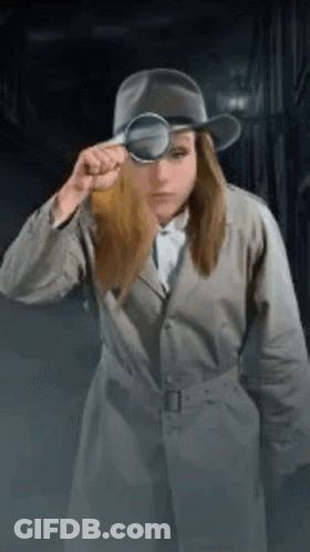 A Woman In A Trench Coat And Hat Is Looking Through A Magnifying Glass . GIF
