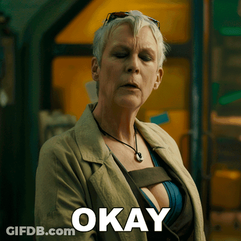 A Woman In A Trench Coat Has The Word Okay Written On Her Chest GIF