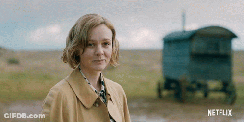 A Woman In A Trench Coat Stands In A Field With A Netflix Logo In The Corner GIF