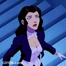 A Woman In A Tuxedo And Bow Tie Is Standing In Front Of Stairs GIF