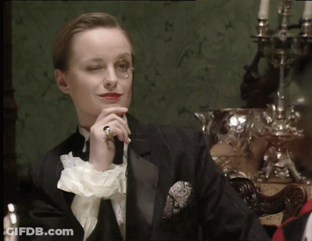 A Woman In A Tuxedo Has A Ring On Her Left Hand GIF