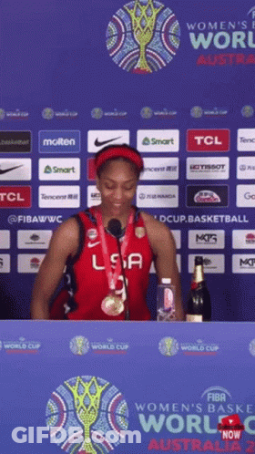 A Woman In A Usa Jersey Stands In Front Of A Sign That Says Women 'S World Cup Australia 2 GIF