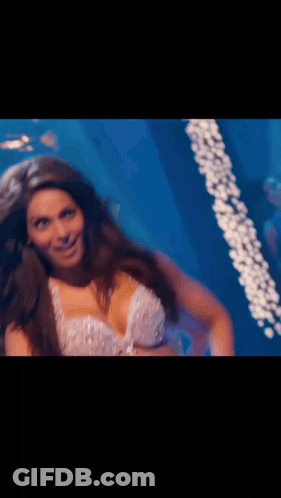 A Woman In A Very Revealing Top Is Dancing In A Dark Room GIF