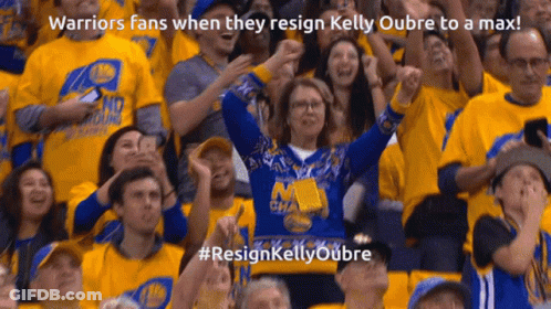 A Woman In A Warriors Sweater Stands In A Crowd GIF