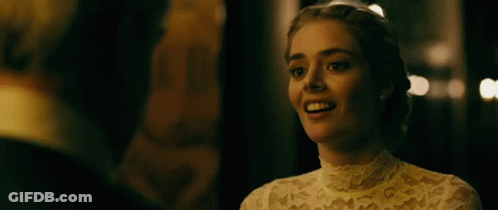 A Woman In A Wedding Dress Is Laughing With A Man In A Tuxedo . GIF