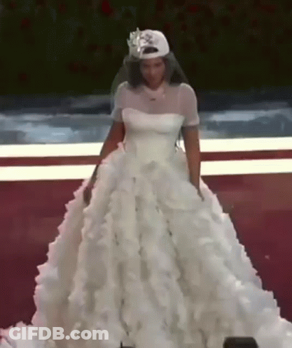A Woman In A Wedding Dress Is Wearing A Baseball Cap And Veil . GIF