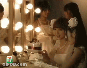 A Woman In A Wedding Dress Looks At Herself In A Mirror With A 7 Eleven Logo On It GIF