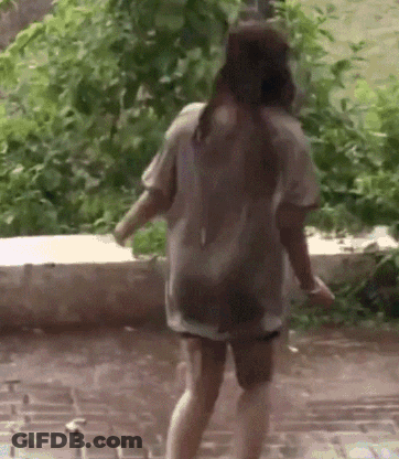 A Woman In A Wet Shirt Is Walking In The Rain GIF