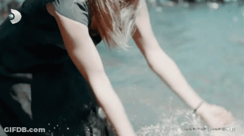 A Woman In A Wetsuit Is Reaching Into The Water With A Linkedin Logo In The Background GIF