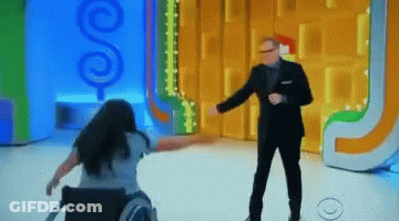 A Woman In A Wheelchair Is Dancing In Front Of A Man In A Suit GIF
