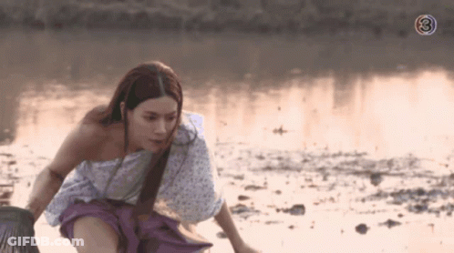 A Woman In A White And Purple Dress Is Kneeling In The Water With The Number 3 Behind Her GIF