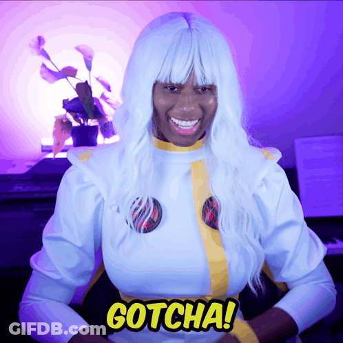 A Woman In A White Costume With The Word Gotcha On Her Chest GIF